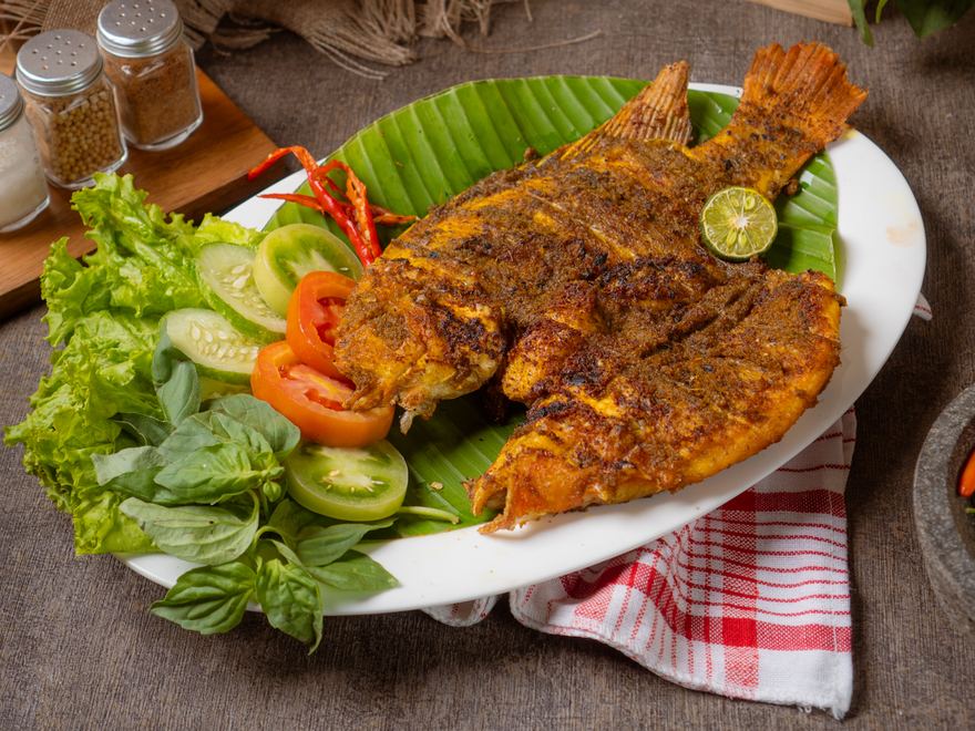 Ikan Nila Bakar Awi Legit — nila utuh dibakar berbumbu kuning, disajikan dengan lalapan segar, tomat, kemangi, dan jeruk limau